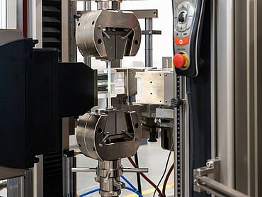 Laserextensometer mit Kurzofen ermöglicht die Dehnungsmessung an Flachproben bis +1.400°C, die außerhalb des Ofens gespannt werden.