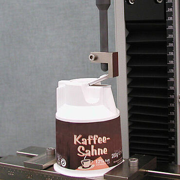 プラスチックコンポーネントの試験: プラスチック製の半製品および完成品の試験の例としての、コーヒークリーマー容器の活性化力